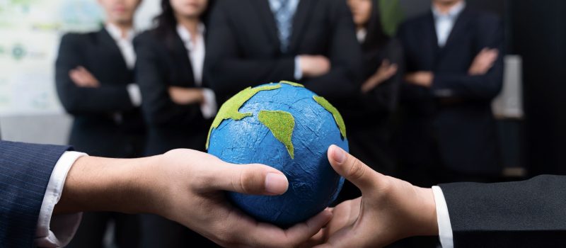 Top view business people holding Earth together in synergy as team building to utilize eco regulation for environmental protection by reducing CO2 emission to save Earth. Quaint